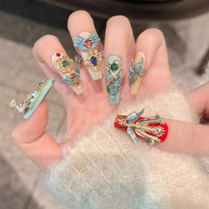 Close-up of a hand with intricately designed nails featuring colorful gemstones.