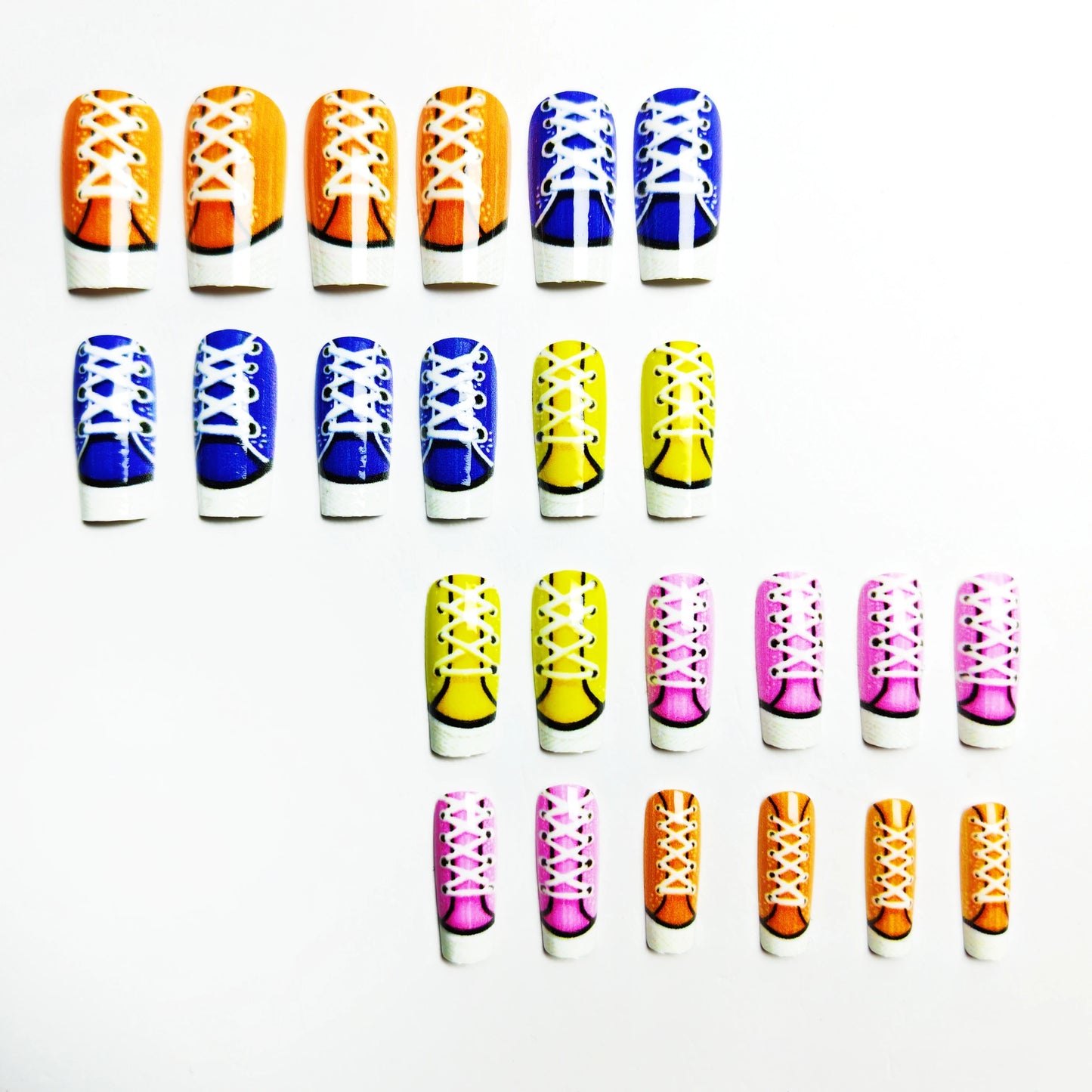 Colorful nail art designs resembling sneakers on a white background