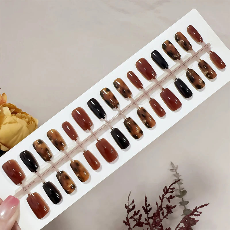 Set of brown and black nail samples on a display card.