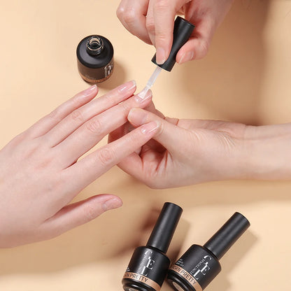 Person applying nail polish to another person's nails with a beige background