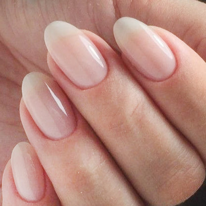 Close-up of a hand with soft pink nail polish on a neutral background