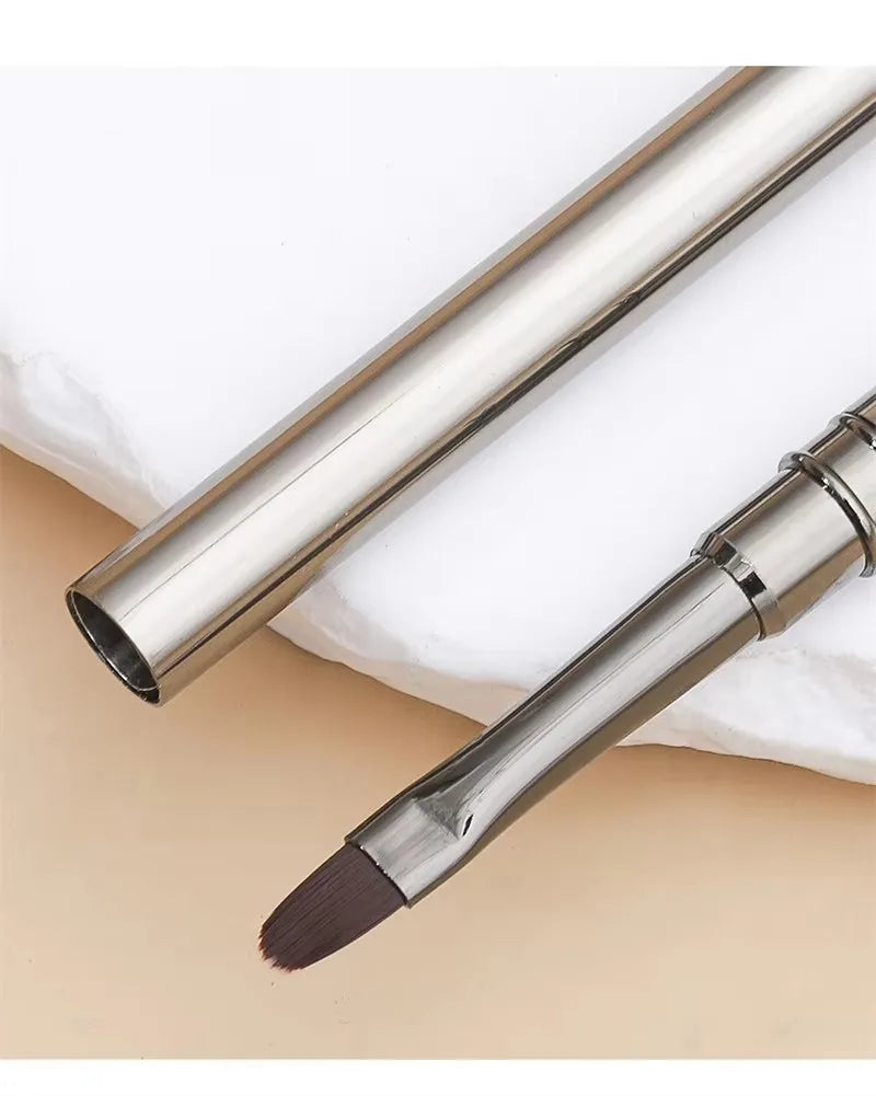 Makeup brush with a metallic handle on a beige background