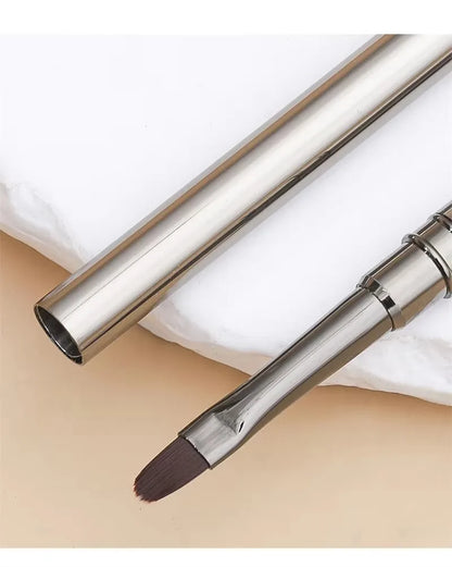 Makeup brush with a metallic handle on a beige background