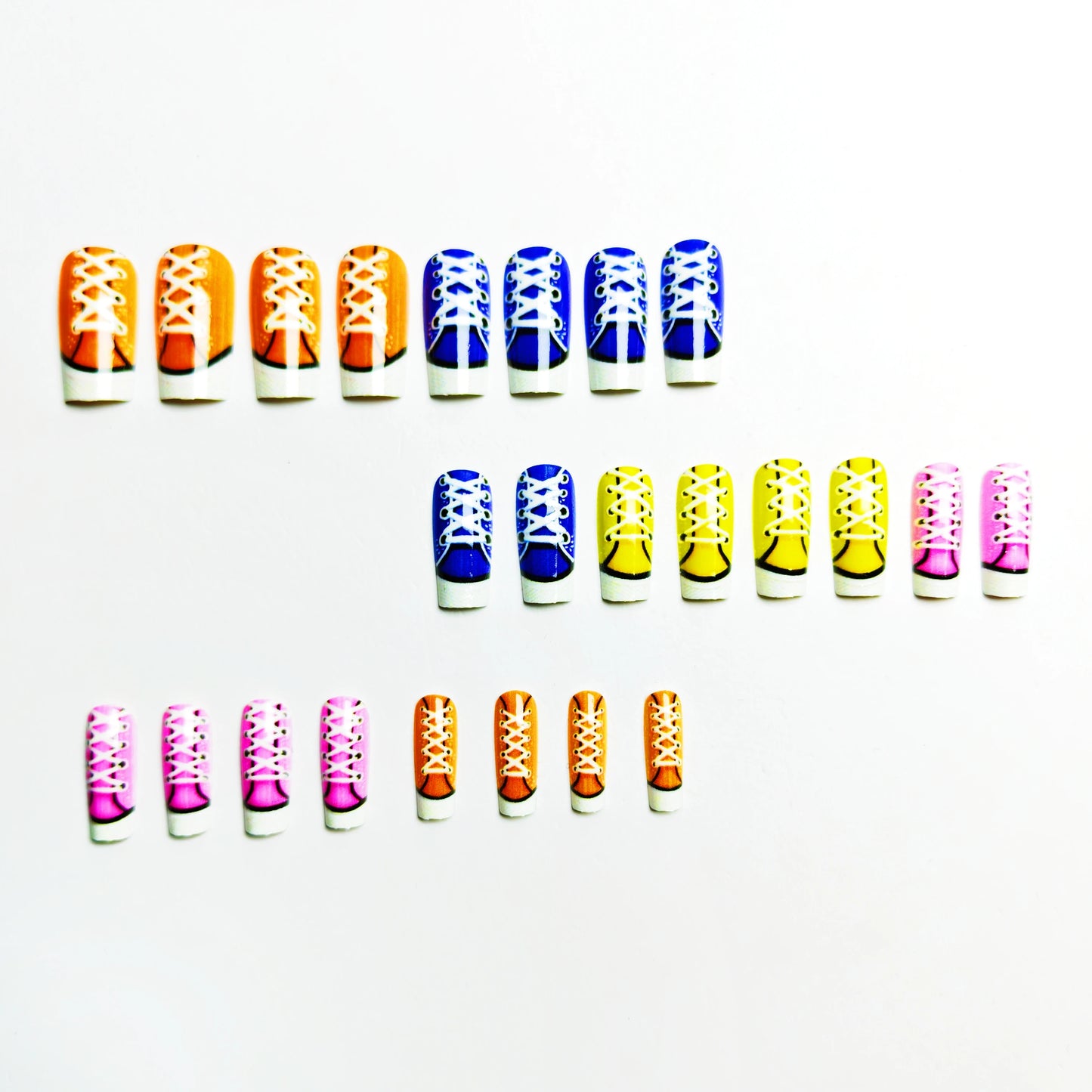Colorful nail art designs resembling shoes on a white background