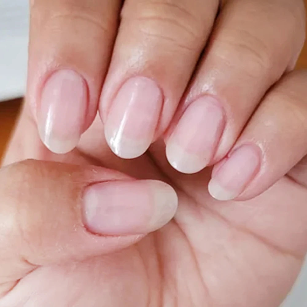 Close-up of a hand with soft pink nail polish on a neutral background