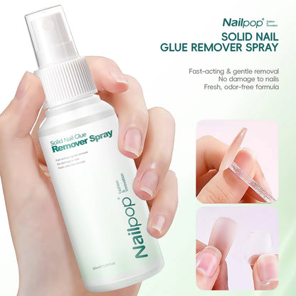 Nailpop solid nail glue remover spray held by a hand with a close-up of nails being treated.