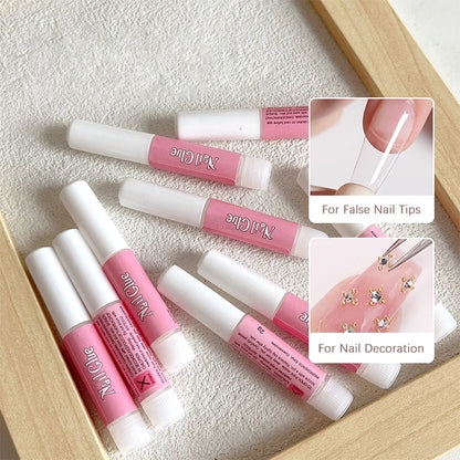 Set of pink and white nail art tools with a wooden box on a textured surface.